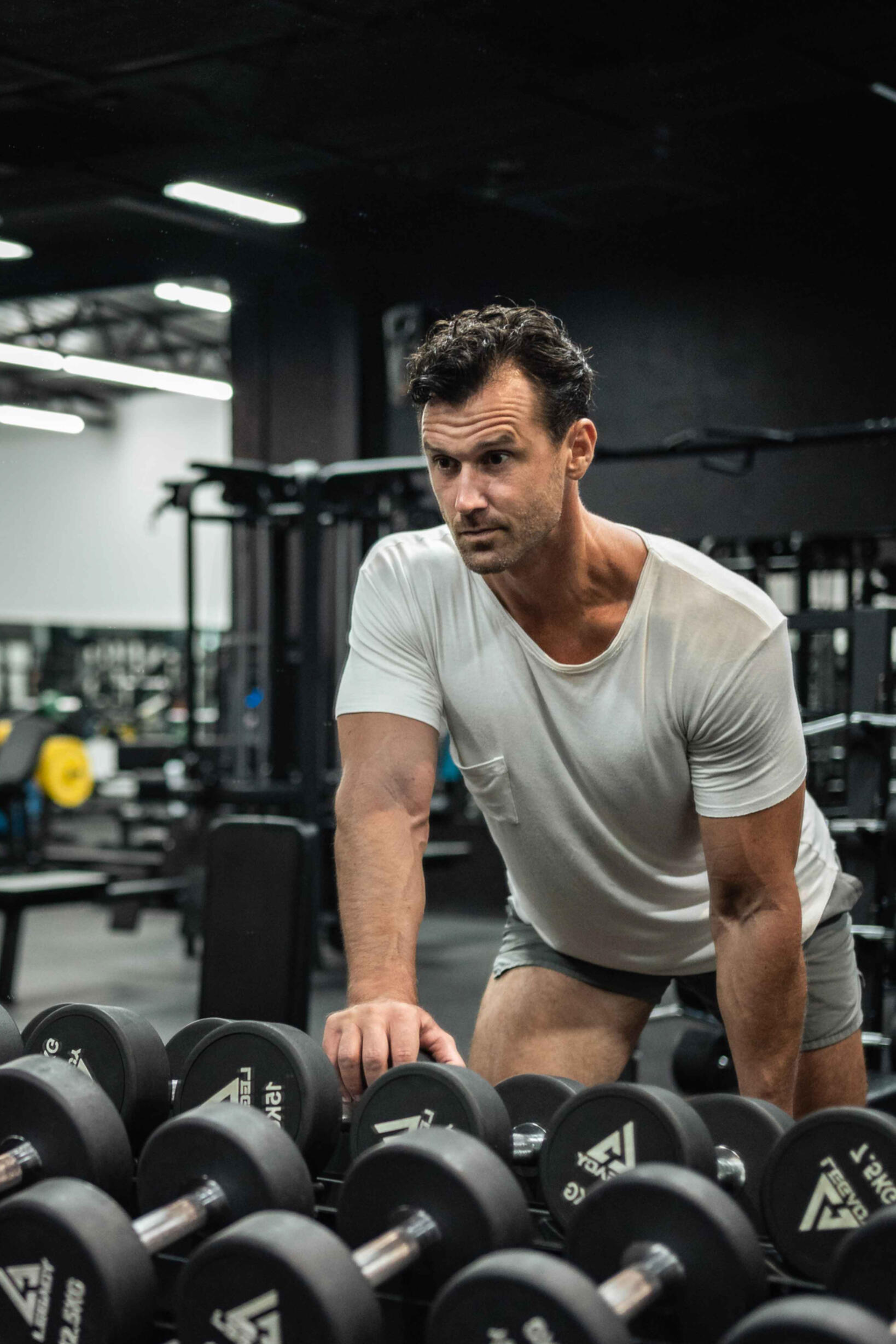 Paul Marlow doing a dumbbell single arm row in the gym this is a photo of Paul Marlow training as a tall man doing a dumbbell single arm row in the gym